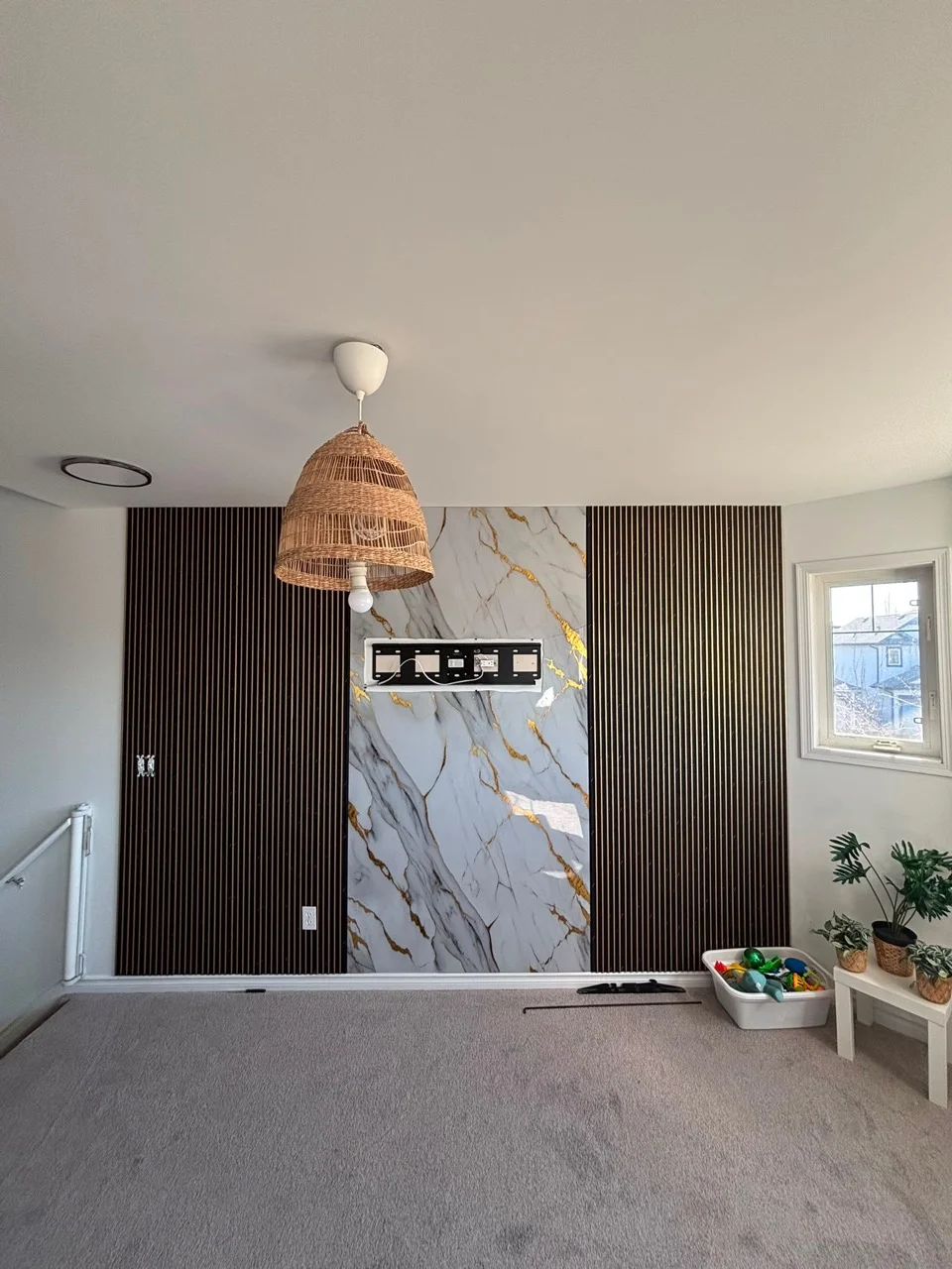 Living room wall combining vertical slats and a white and gold veined centre panel